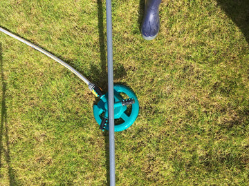 A rotating sprinkler becomes a water fountain with a carefully positioned broom